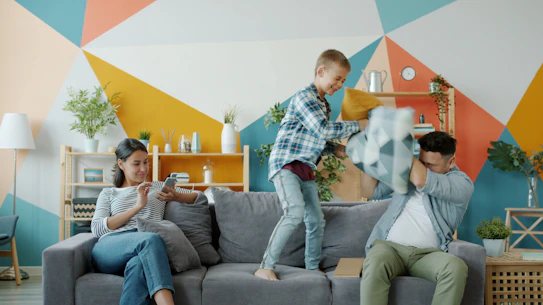 Family having a pillow fight on the couch.
