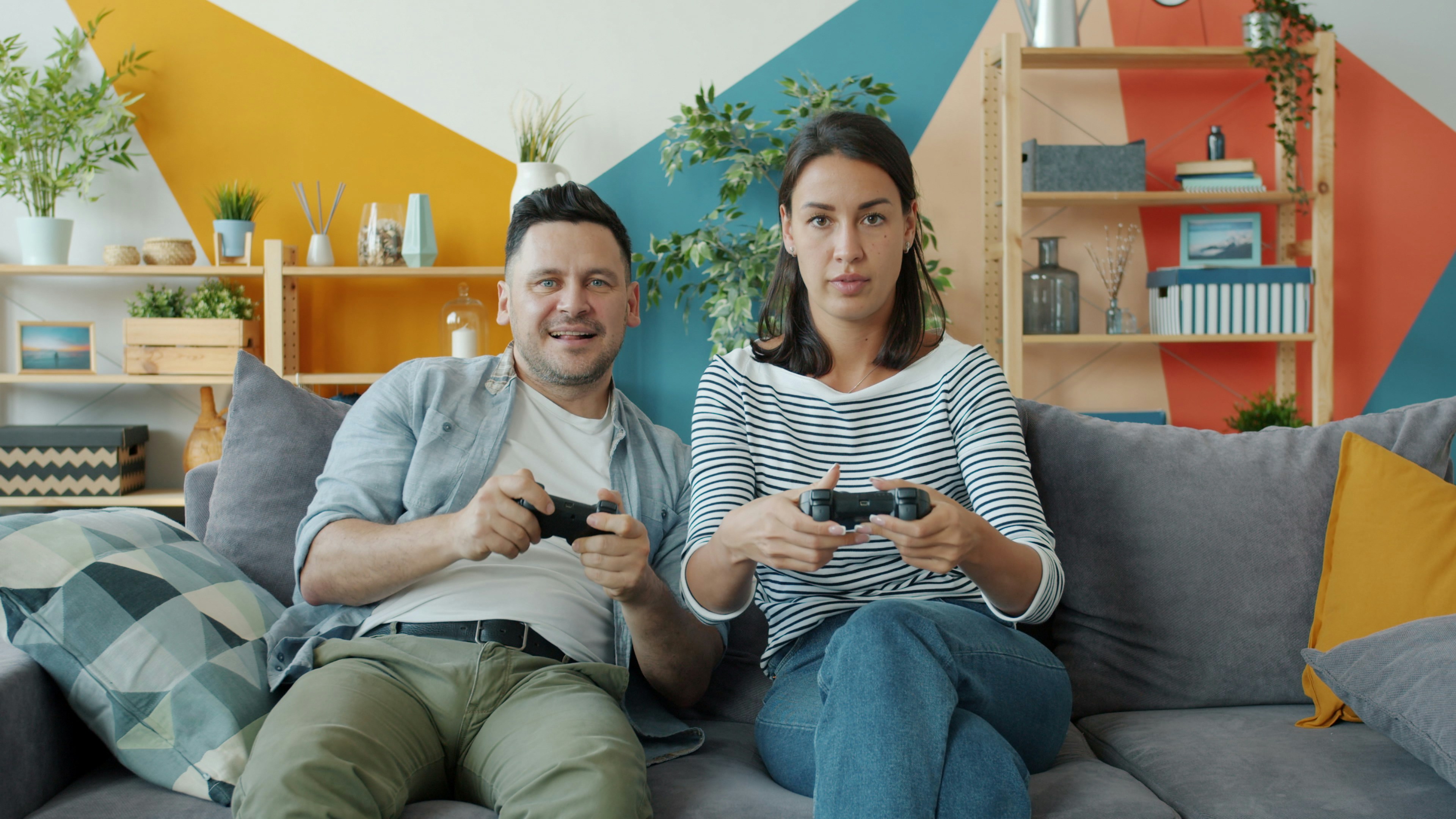 Couple playing video games on sofa