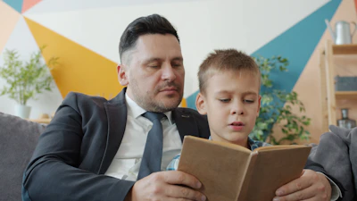 Father and son reading together caregiver training ABA therapy Savannah