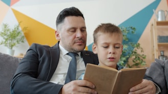 Padre e hijo leyendo un libro juntos.