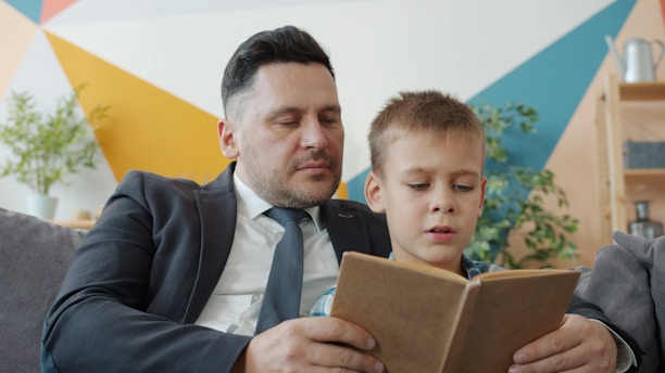 Padre e hijo leyendo un libro juntos.