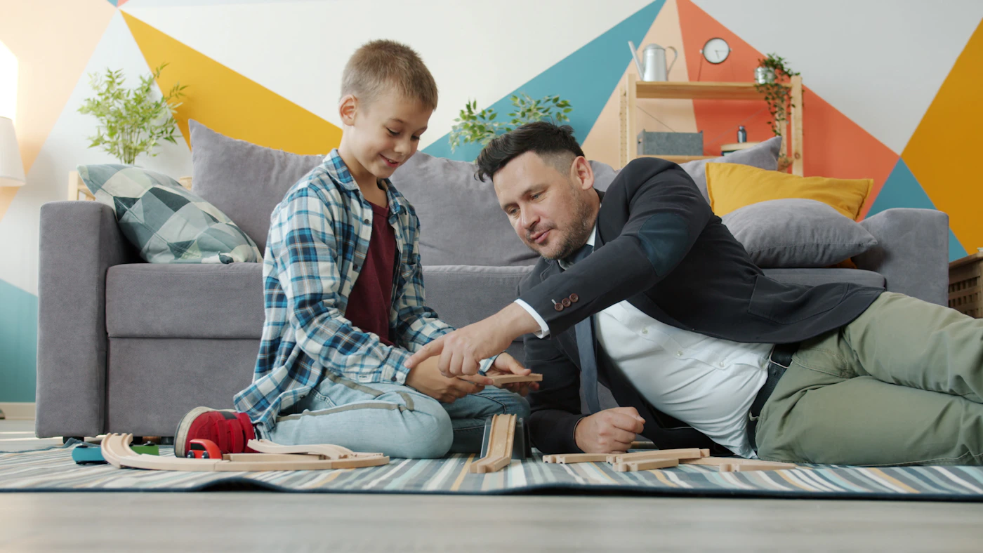 Parent and child creating together with colorful wooden building pieces