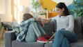 Mother comforts upset child on the sofa