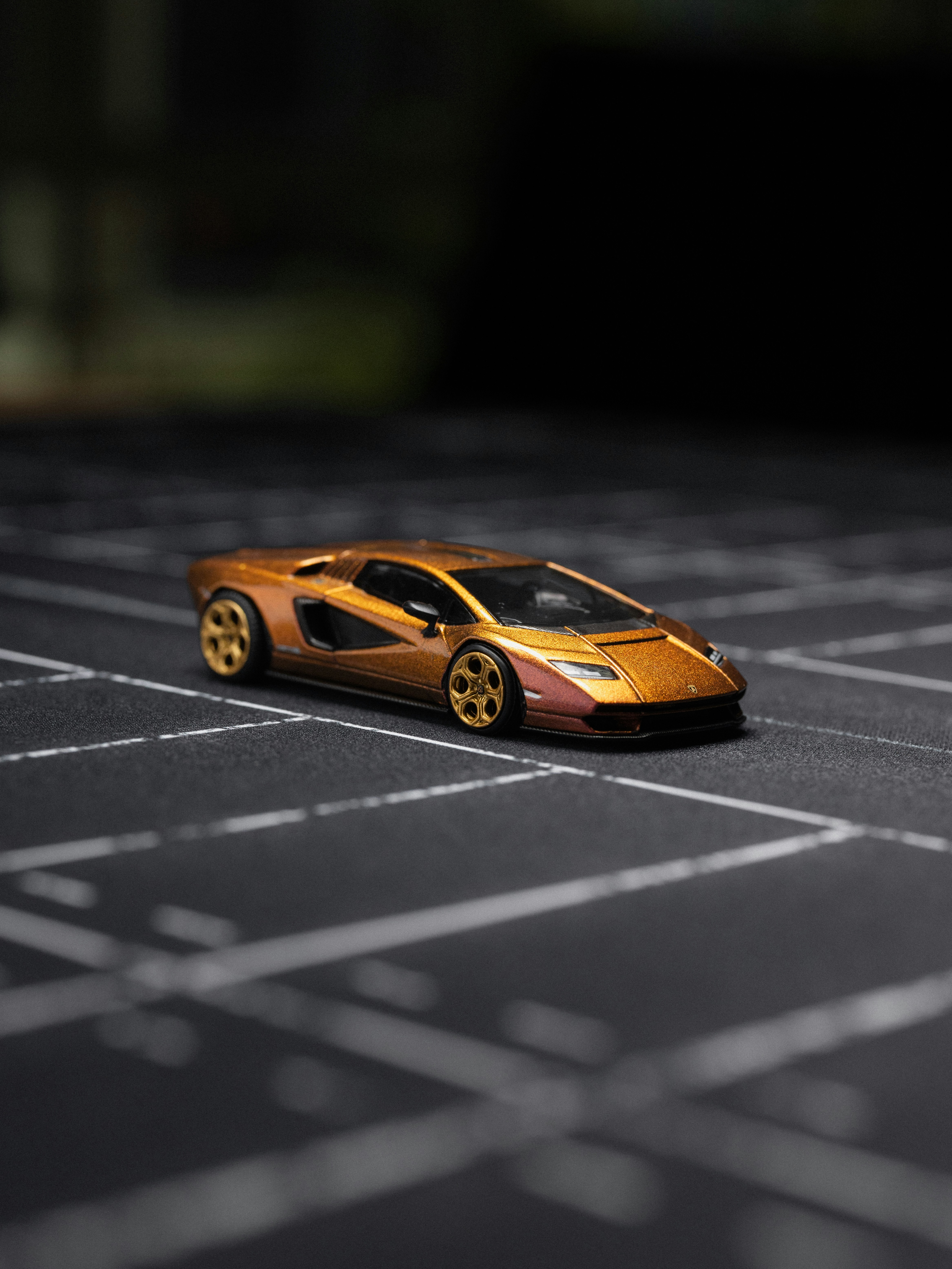 A gold sports car on a black surface.