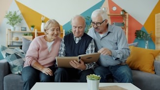 Three seniors looking at a photo album together.