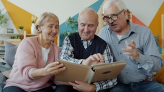 Three seniors looking at a photo album together