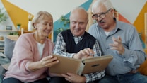 Three seniors looking at a photo album together