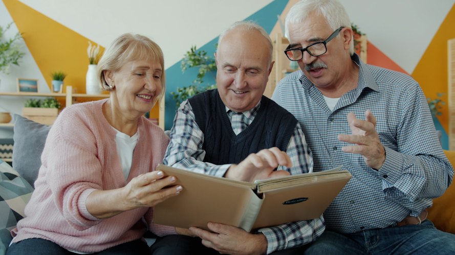 An adult child and an older parent looking at a phone screen together
