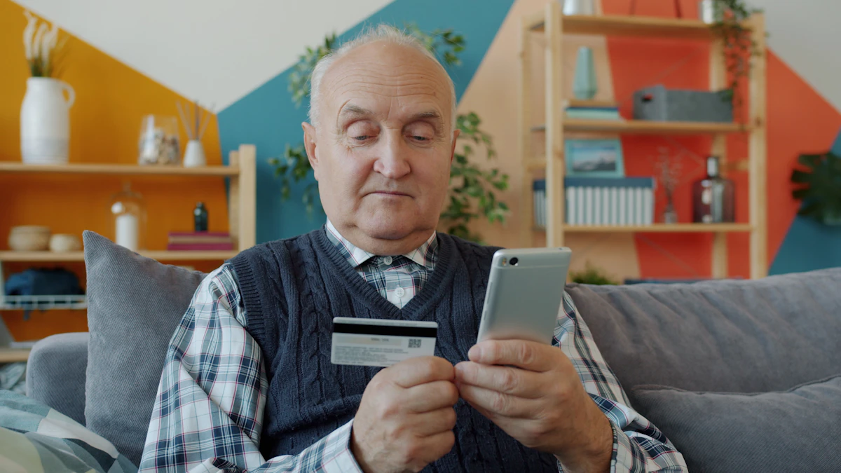 Ældre mand med betalingskort og smartphone i gang med netbank