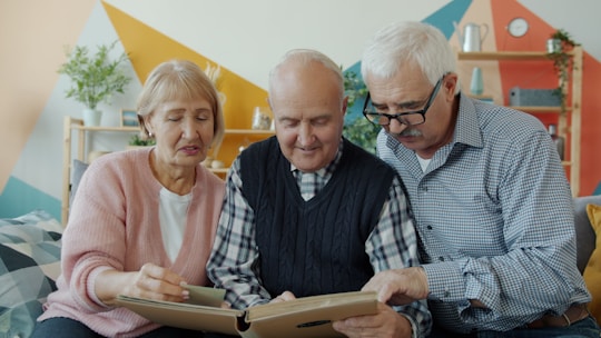 Three seniors looking at a photo album together