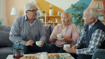 Three seniors enjoying coffee and conversation at home