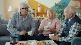 Three seniors enjoying coffee and conversation at home.