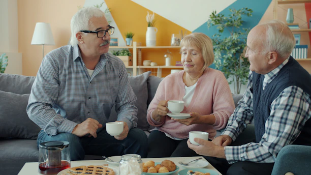Three seniors enjoying coffee and conversation at home.