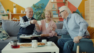 Seniors sharing a photograph while having tea.