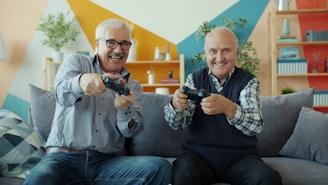 Two smiling elderly men playing video games together.