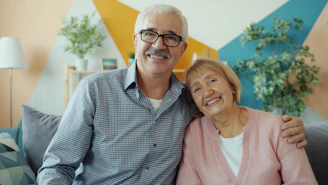 Elderly couple smiling together on a couch.
