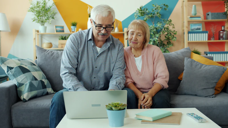 An older couple looking at a laptop together at home