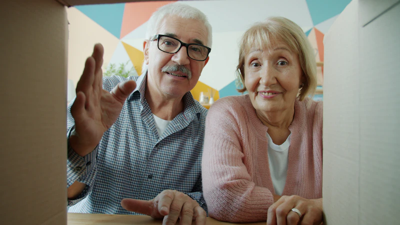 elderly couple curiously looking into a cardboard box