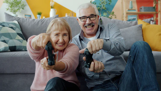 Elderly couple playing video games together with controllers
