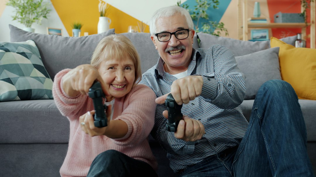Elderly couple playing video games together with controllers