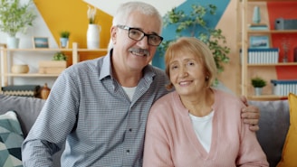 Elderly couple smiling together on a couch.