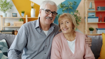 Elderly couple smiling together on a couch.