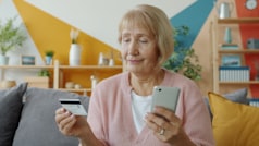 Mujer mayor usando smartphone para generar ingresos rapidos en Espana