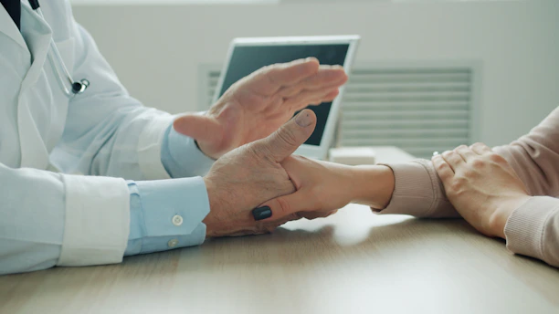 Doctor comforting patient with a hand on arm.