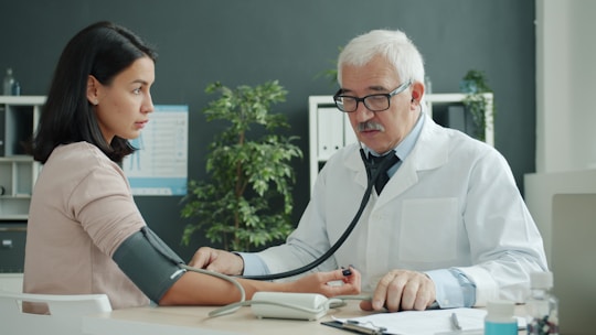 Doctor taking patient blood pressure in a calm clinic representing Healthcare Vastu 