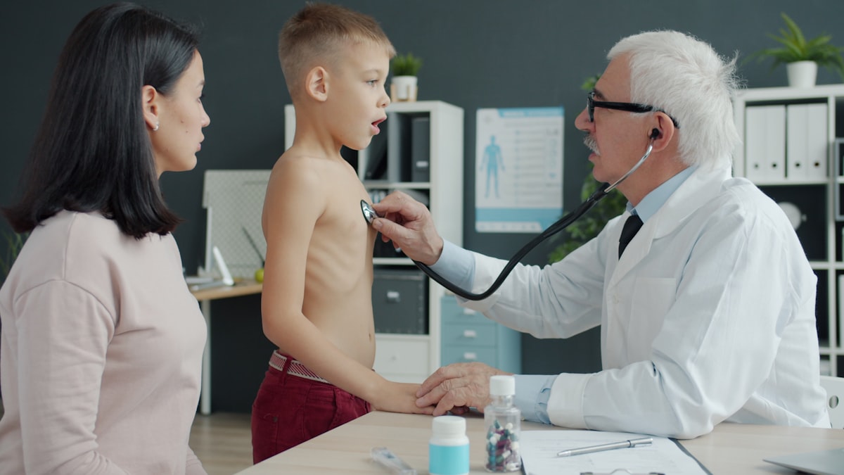 Pediatrician listening to a young boy's heartbeat with a stethoscope