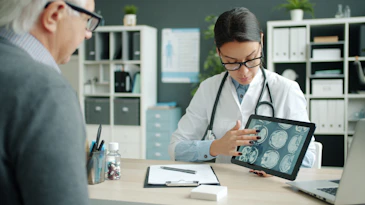 Doctor shows patient brain scans on tablet