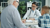Doctor consulting with elderly man and child.