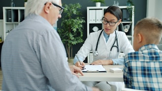 Doctor consulting with elderly man and child.