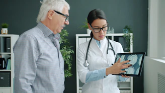 Doctor shows medical scan to elderly patient
