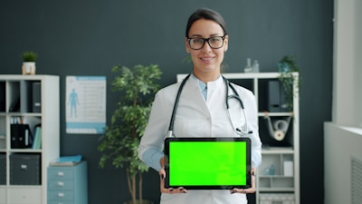 Doctor holding a tablet with a green screen.