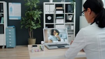 Doctor consulting patient via video call on laptop.