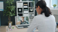 Doctor consulting patient via video call on laptop
