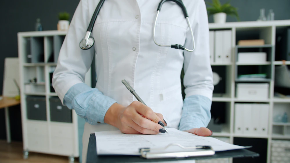 Doctor reviewing and documenting patient records in an office setting