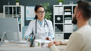 Doctor consults with patient in medical office.