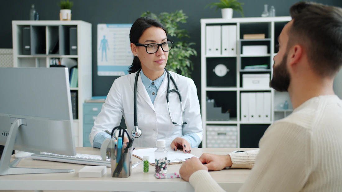 Specialist reviewing a chronic-care patient during an in-person clinic visit