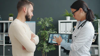 Doctor shows patient medical scan on tablet