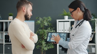 Doctor shows patient medical scan on tablet.