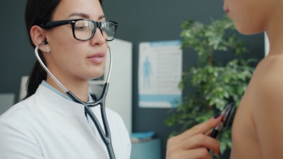 Doctor examines child with stethoscope in clinic.