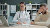 Doctor consults with a distressed male patient in office