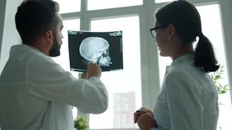 Two doctors examine a skull x-ray together
