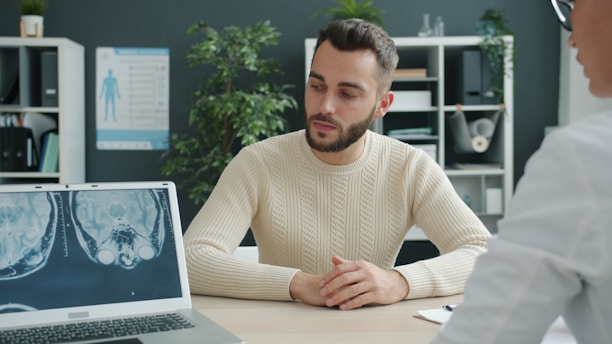 Man talking to doctor with mri scan on laptop