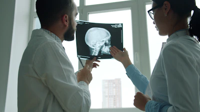 Doctors examine a skull x-ray in a bright room.
