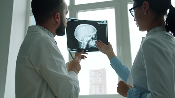 Doctors examine a skull x-ray in a bright room.