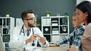 Doctor talks to mother and son in office.