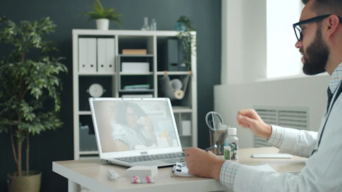 Médico frente a su laptop en el consultorio